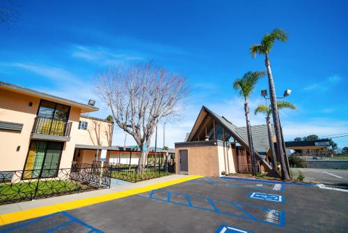 a parking lot in front of a building with palm trees at Hotel Calle Joaquin - San Luis Obispo in San Luis Obispo