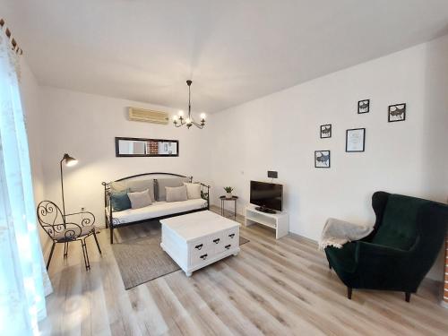 a living room with a bed and a couch and a tv at Villa Blatina in Gradac