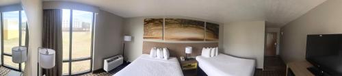 a room with three white chairs and a large window at Days Inn by Wyndham Fayetteville-South/I-95 Exit 49 in Fayetteville