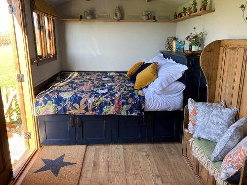 Un dormitorio con una cama con almohadas. en Marsh Farm Glamping Shepherd Hut, en Langport