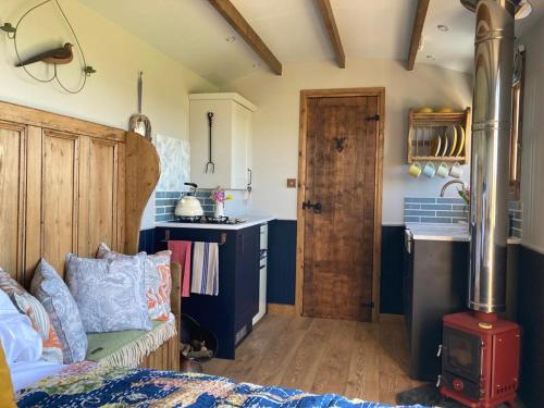 a room with a kitchen with a stove in it at Marsh Farm Glamping Shepherd Hut in Langport