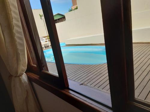 a view of a swimming pool from a window at Sol poente in Florianópolis