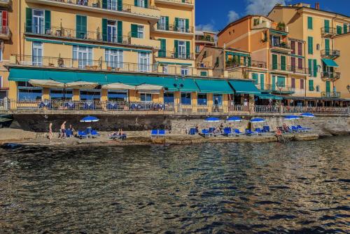 a beach with chairs and umbrellas next to the water at Hotel Italia e Lido Rapallo in Rapallo