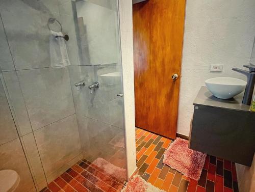 a bathroom with a shower with a glass door at The Naked House - Hotel Nudista in Nemocón