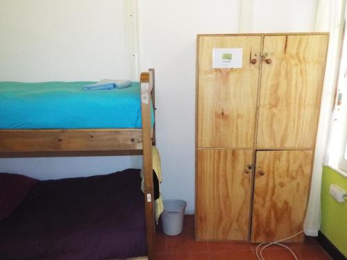 a bedroom with a bunk bed and a wooden cabinet at Hostal Casa Verde Limón in Valparaíso