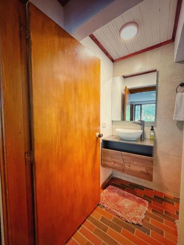 a bathroom with a wooden door and a sink at The Naked House - Hotel Nudista in Nemocón