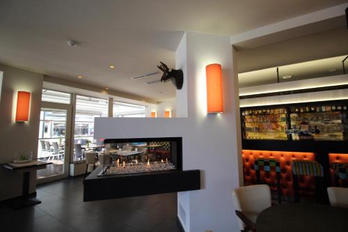 a lobby with a fireplace in a restaurant at Hotel La Terrasse in De Panne