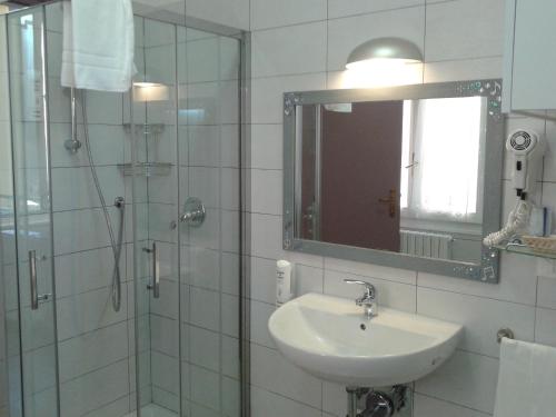 a bathroom with a sink and a shower with a mirror at Hotel Centrale in Bologna