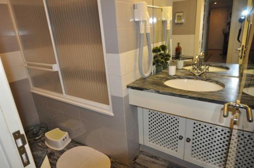 a bathroom with a sink and a mirror at Apart Lisbon Pool Metro Garage in Lisbon