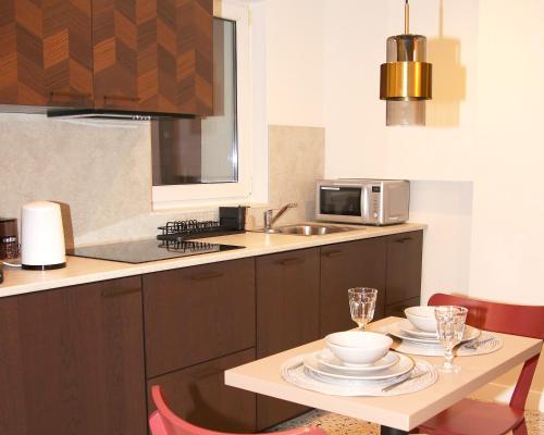 uma cozinha com uma mesa com pratos e copos em Falcon Apartment Center 1 Warszawa Centralna em Varsóvia