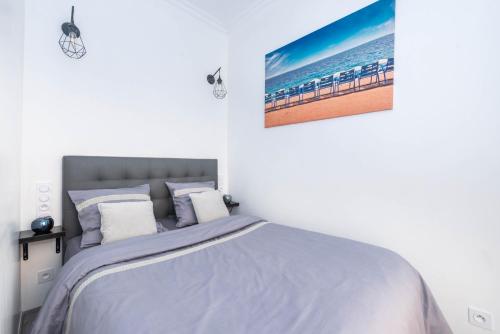 a bedroom with a bed and a picture of the beach at Nice Centre Flat - Modern, Quiet and Brand New in Nice