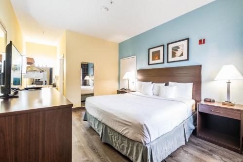 a hotel room with a bed and a desk at Days Inn by Wyndham Federal Way in Federal Way
