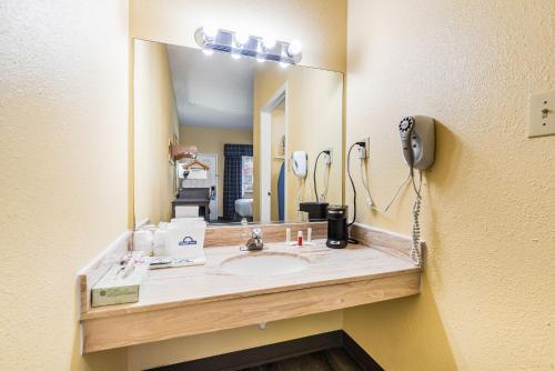 a bathroom with a sink and a mirror at Days Inn by Wyndham Federal Way in Federal Way