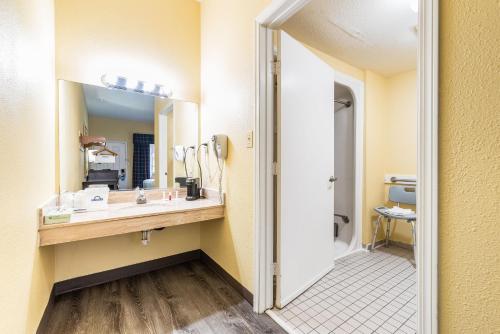 a bathroom with a sink and a mirror at Days Inn by Wyndham Federal Way in Federal Way