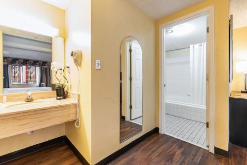 a bathroom with a sink and a mirror at Days Inn by Wyndham Federal Way in Federal Way