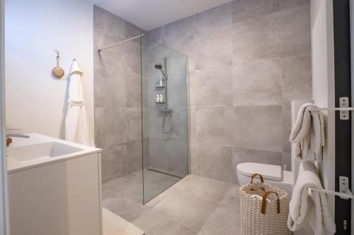 a bathroom with a shower and a toilet and a sink at The Loft - Full Sea View - use of hotels Sauna and Pool in Cadzand