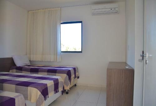 a room with two beds and a window at Casa de Praia in Porto De Galinhas
