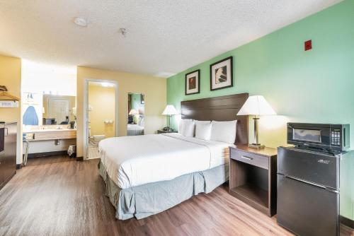 a hotel room with a bed and a television at Days Inn by Wyndham Federal Way in Federal Way