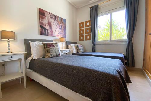 1 dormitorio con 2 camas y ventana en Mar Menor Villa, en Torre-Pacheco
