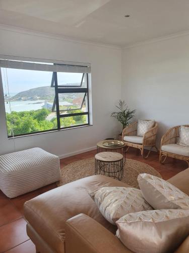 a living room with a couch and a large window at Struispaleis in Struisbaai