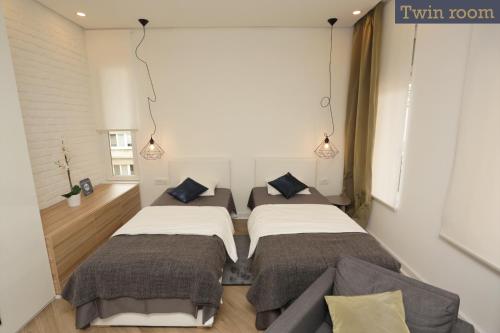 a bedroom with two beds and a couch at Moment Boutique Apartments in Belgrade