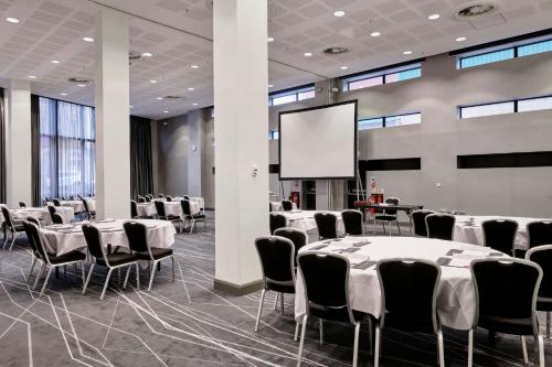 a conference room with tables and chairs and a screen at Crowne Plaza Manchester City Centre by IHG in Manchester