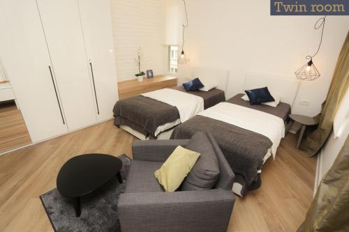 a living room with two beds and a couch at Moment Boutique Apartments in Belgrade