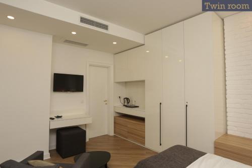 a bedroom with white walls and a bed and a desk at Moment Boutique Apartments in Belgrade