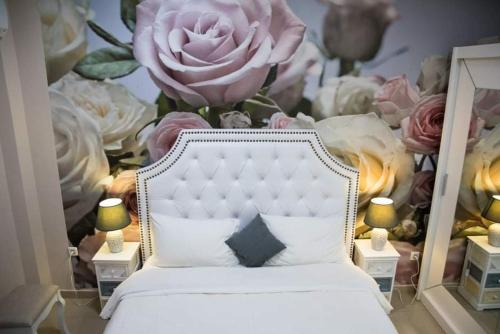 una camera da letto con un letto bianco e un murale di fiori di Boutique lux apartments a Kavala