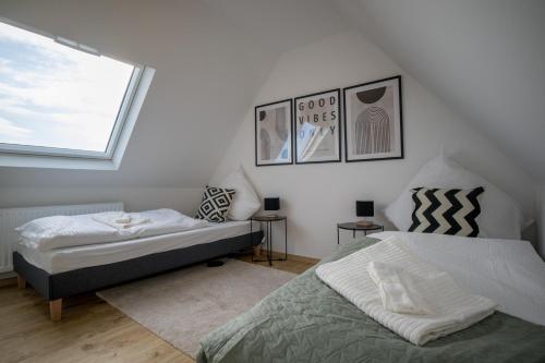 1 dormitorio con 2 camas y ventana en 110 qm Penthousewohnung bei Bonn / Köln en Lohmar