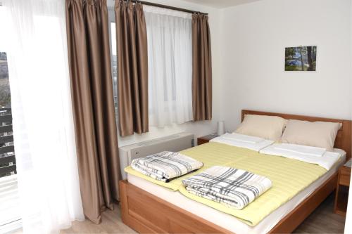 a bedroom with a bed with yellow sheets and a window at Apartmani Stefan in Vrdnik
