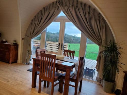Charlton Musgrove的住宿－Riding Gate Lodge，一间带桌椅和大窗户的用餐室