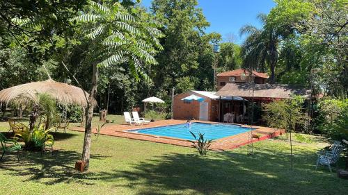 ein Schwimmbad in einem Hof neben einem Haus in der Unterkunft Posada Turística Las Orquídeas in Cambyretá