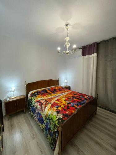 1 dormitorio con 1 cama con colcha colorida en Savonarola 45_Casa completa nel centro storico, en Latronico