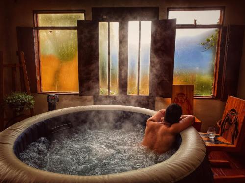 a man sitting in a bath tub in a room at The Naked House - Hotel Nudista in Nemocón
