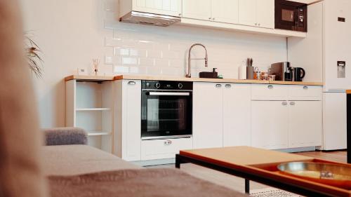 een keuken met witte kasten en een fornuis met oven bij The Perfect Space - NEWStudio - PS4 & Bicycle & Parking in Târgu-Mureş