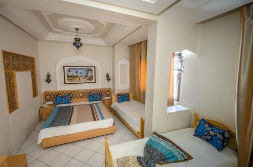 Habitación con 2 camas y 2 sillas. en Saheb Ettabaa Tunis, en Túnez