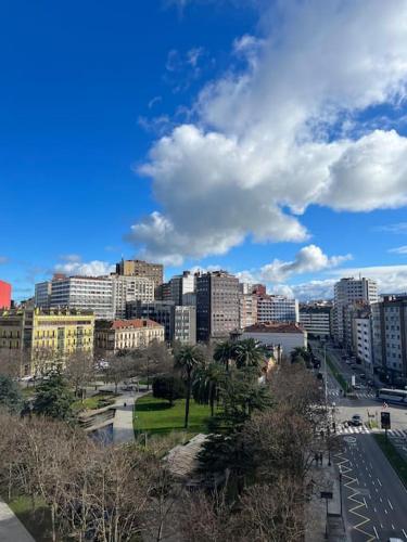 a city with tall buildings and a blue sky with clouds at Tía Ana in Gijón