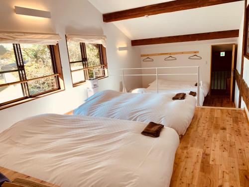 2 weiße Betten in einem Schlafzimmer mit 2 Fenstern in der Unterkunft Satoyama villa DEN - Vacation STAY 14150 in Matsumoto