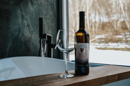 a bottle of wine and a glass on a table at Forrest Space - wyjątkowy dom otoczony naturą in Wola Rafałowska