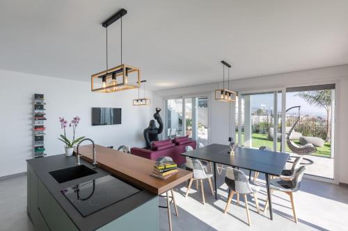 eine Küche und ein Wohnzimmer mit einem Tisch und Stühlen in der Unterkunft Villa la Matta in Sanremo