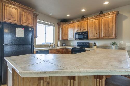 a kitchen with wooden cabinets and a large counter top at 2012 LP PS4, Private Balcony with Beautiful Mountain Views, and Great Clubhouse Amenities in St. George