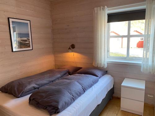 a bed in a room with two pillows on it at Brygga på Dønna 