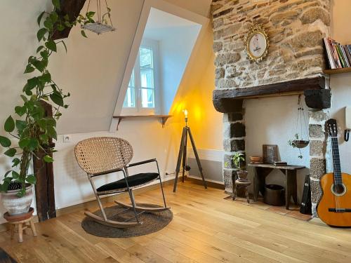 a room with a chair and a guitar in it at Bienvenue à Indra in Vannes