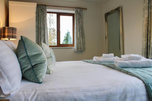 Bedw Barn في نيوتاون: غرفة نوم مع سرير أبيض كبير مع نافذة