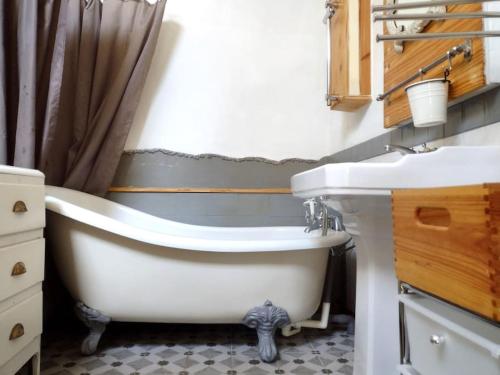 une salle de bain avec une baignoire blanche et un lavabo dans l'établissement Appartement confortable Verdon Provence, à Riez