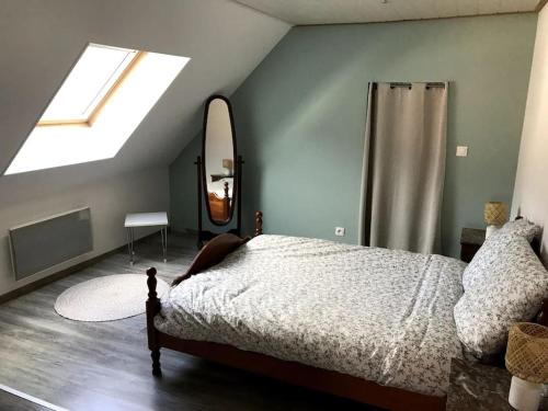 a bedroom with a bed and a window and a mirror at Logement chaleureux, vallée de Villé in Steige