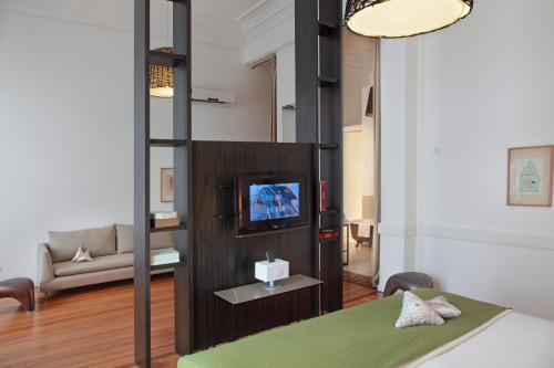 a room with a bed and a tv and a couch at Esplendor by Wyndham Montevideo Cervantes in Montevideo