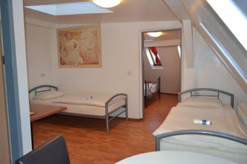 a room with two beds and a mirror at Kölnotel Hostel, Apart & Suite in Cologne