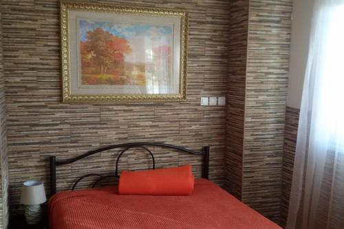 a bedroom with a red bed with a picture on the wall at Sofaki Apartments in Thessaloniki